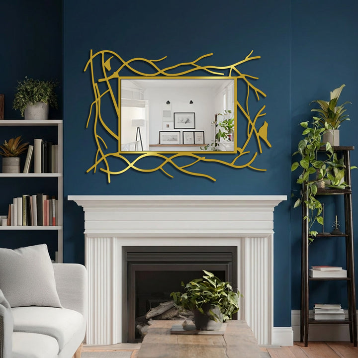 Gleaming framed wall mirror featuring a nature-inspired branch frame with delicate bird accents, serving as the sophisticated focal point above a fireplace mantel.