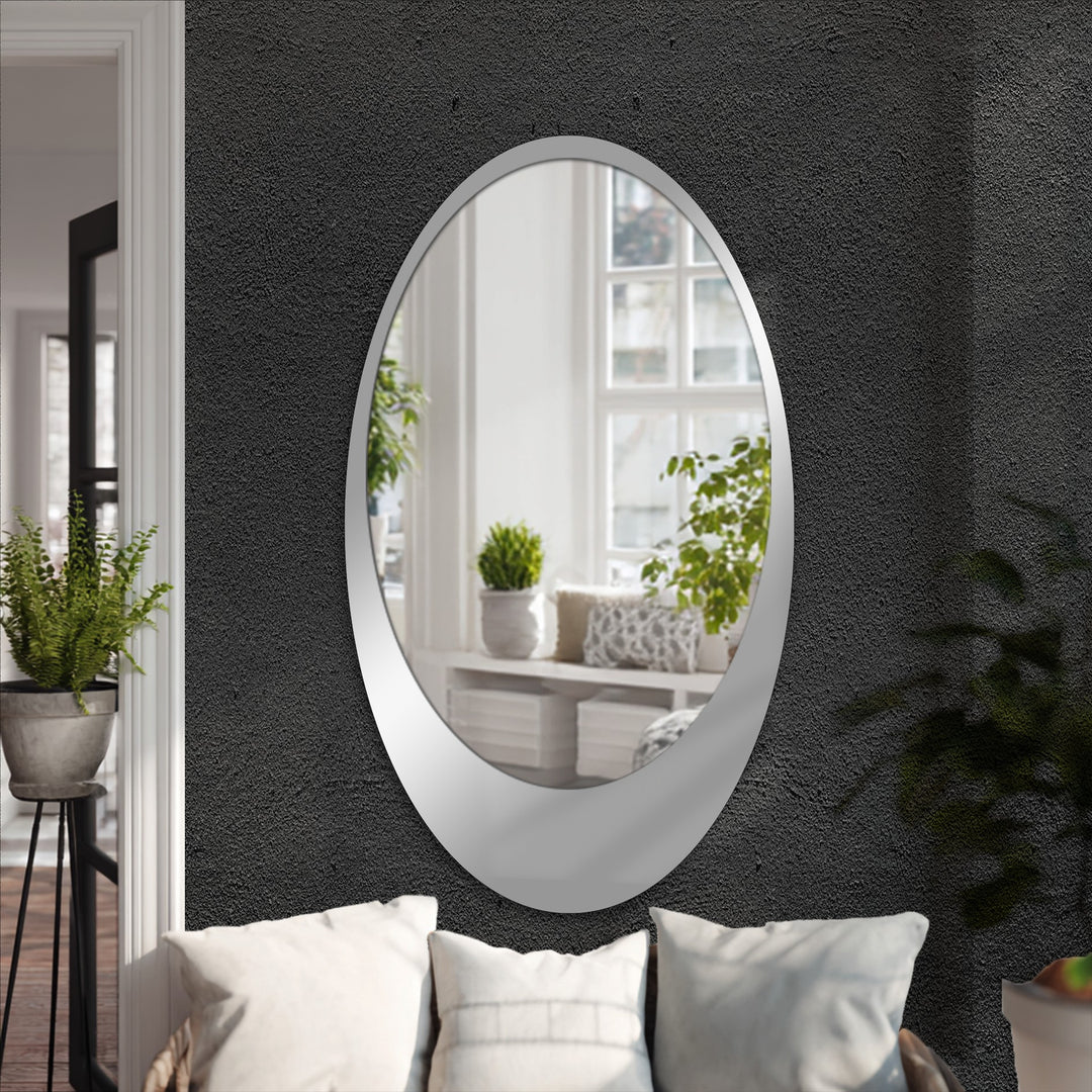 The realistic detail highlights the sleek black framed wall mirror reflecting a sunlit room, positioned above soft cushions for a modern decorative metal art accent.