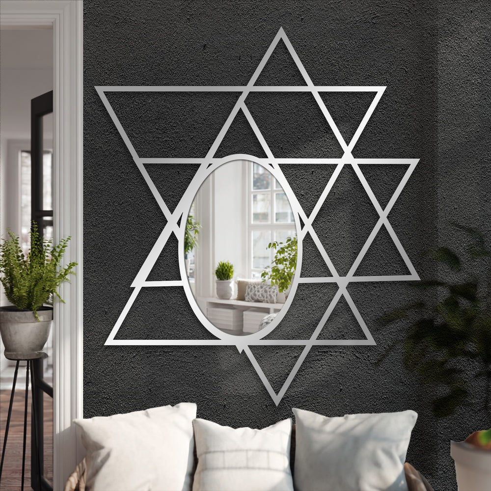 Intersecting triangles create a decorative metal art star around an oval glass in this geometric floor mirror, a modern reflection of minimalist design.
