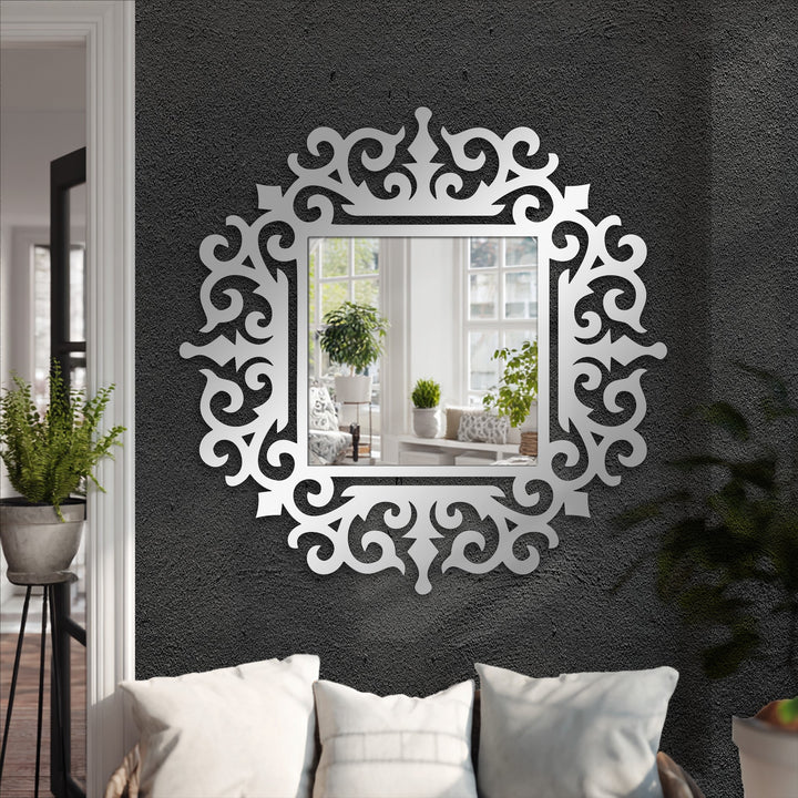 Layered to create depth, a modern mirror reflects an interior scene, framed by a decorative metal art scroll with an ornate baroque design.