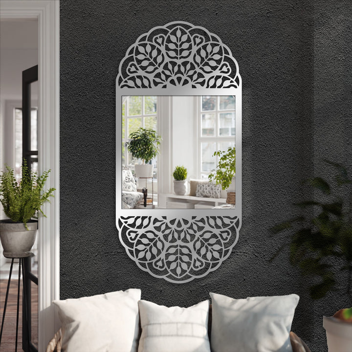 Low color saturation highlights the ornate, floral, metal artwork frame surrounding this modern wall mirrors with a mandala pattern.