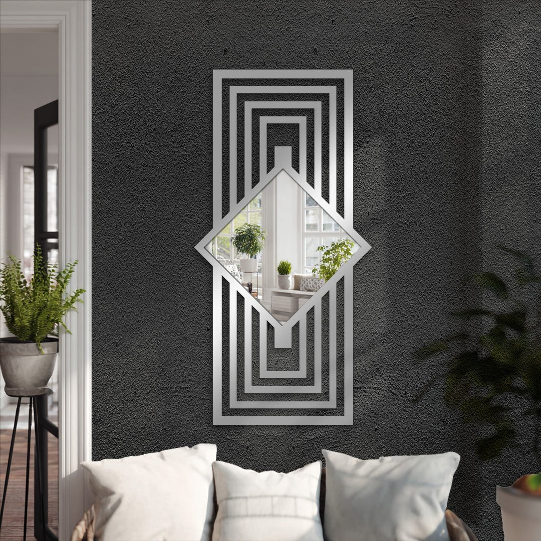 Geometric framed wall mirror reflecting a room and mounted above a sofa is the loudest element, adding a bold art deco touch with its layered frame.