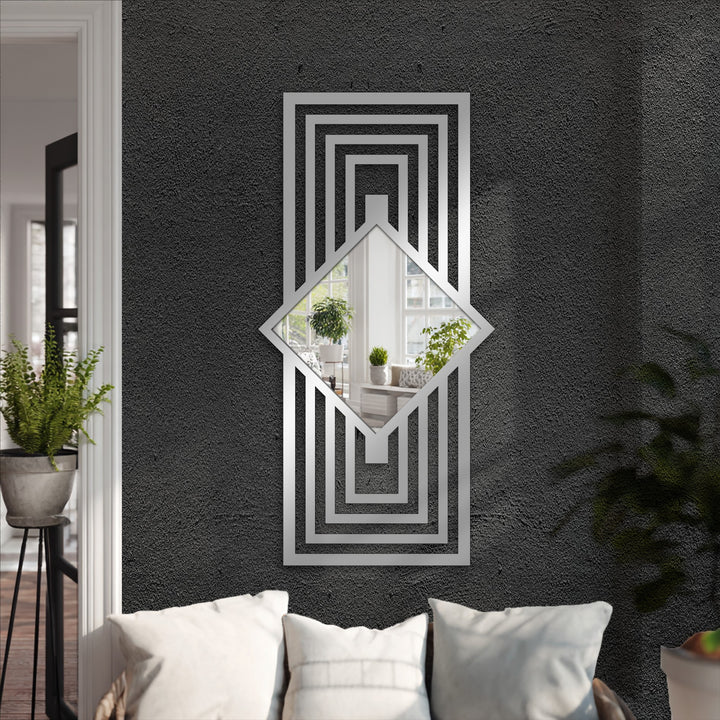 Geometric framed wall mirror reflecting a room and mounted above a sofa is the loudest element, adding a bold art deco touch with its layered frame.