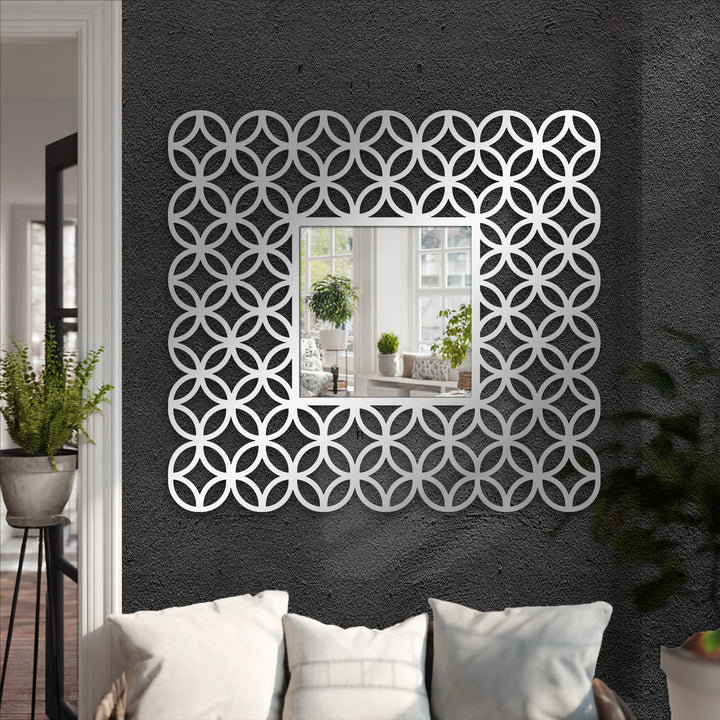 Geometric interlocking ring patterns form a striking, decorative mirror frame, enhancing its unique metal wall art design.