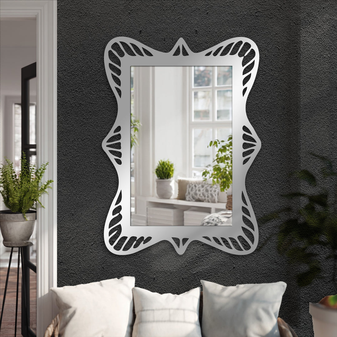 Charcoal gray, the dominant color, highlights the decorative metal art in this ornate wave frame modern mirror, a sculpted rectangular design adding elegance.