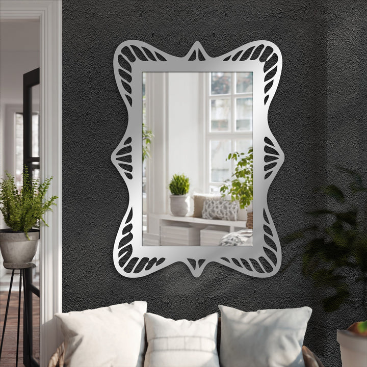 Charcoal gray, the dominant color, highlights the decorative metal art in this ornate wave frame modern mirror, a sculpted rectangular design adding elegance.