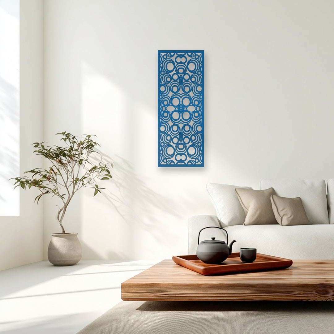 The vibrant blue decorative metal art, featuring a striking geometric circle pattern, boldly accentuates the minimalist white wall.