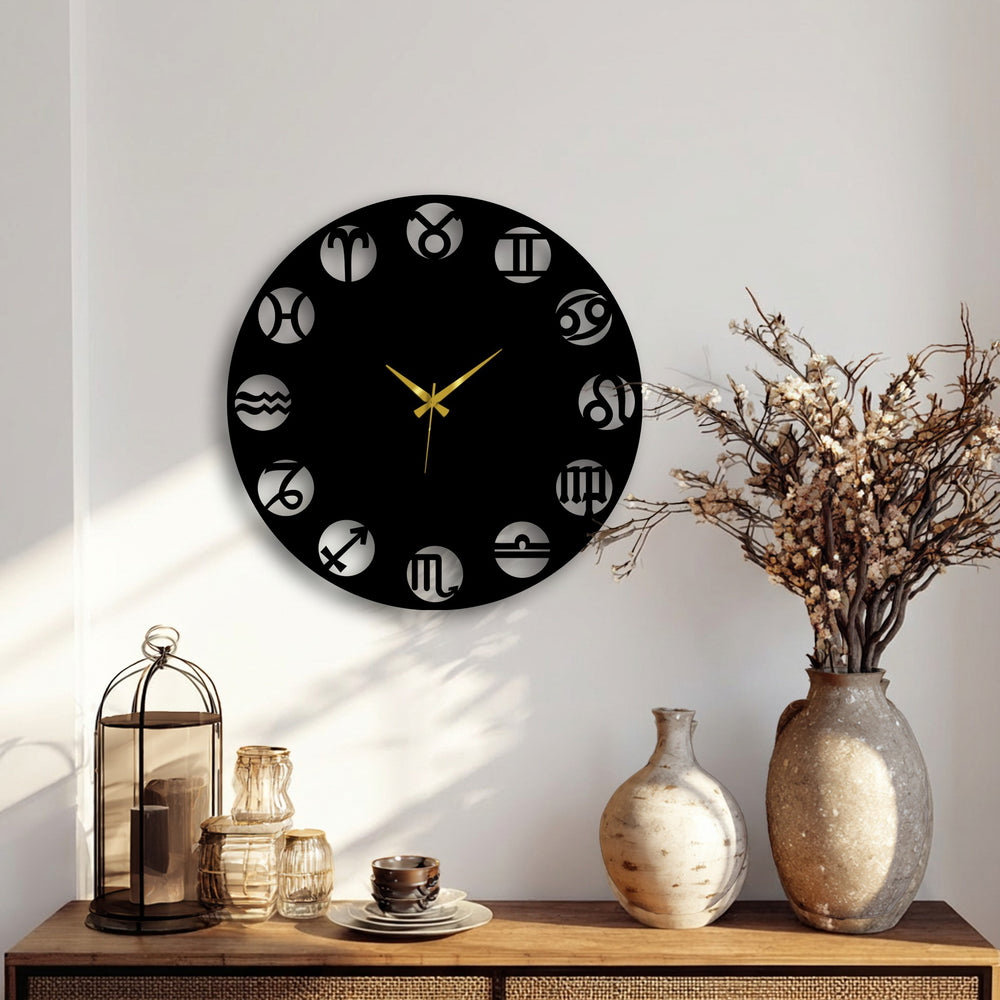 The realistic detail of this black metal artwork zodiac wall clock features precisely cut astrology symbols and gleaming gold hands on a bright wall.