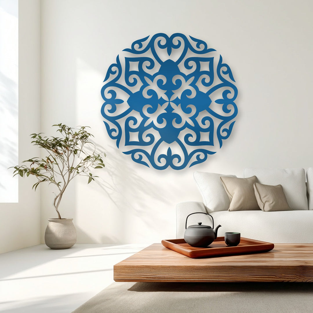 The highly saturated vibrant blue of the ornate floral mandala decoration wall art stands out dramatically against the bright white wall.