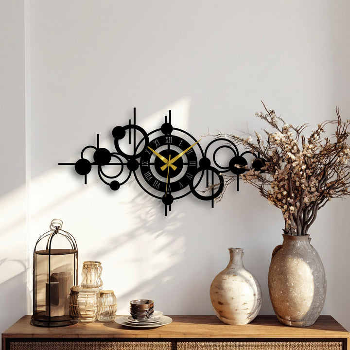 Featuring a matte black decorative metal art finish, this abstract circle orbit metal wall clock offers modern geometric wall decor.
