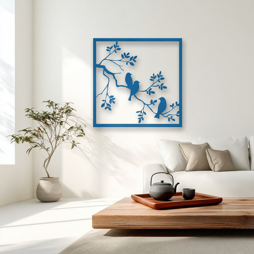 The blue bird and branch metal artwork exhibits a serene visual rhythm through its elegant, repeated natural silhouettes.