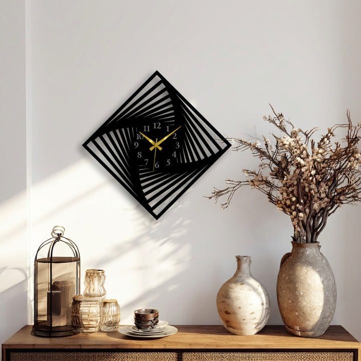 A striking black twisted square wall clock with a modern optical design and contrasting gold hands, serving as unique metal wall art.