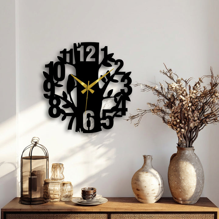 Showing the unique metal wall art of a nature tree design wall clock with its intricate number and branch cutouts casting a slight shadow.