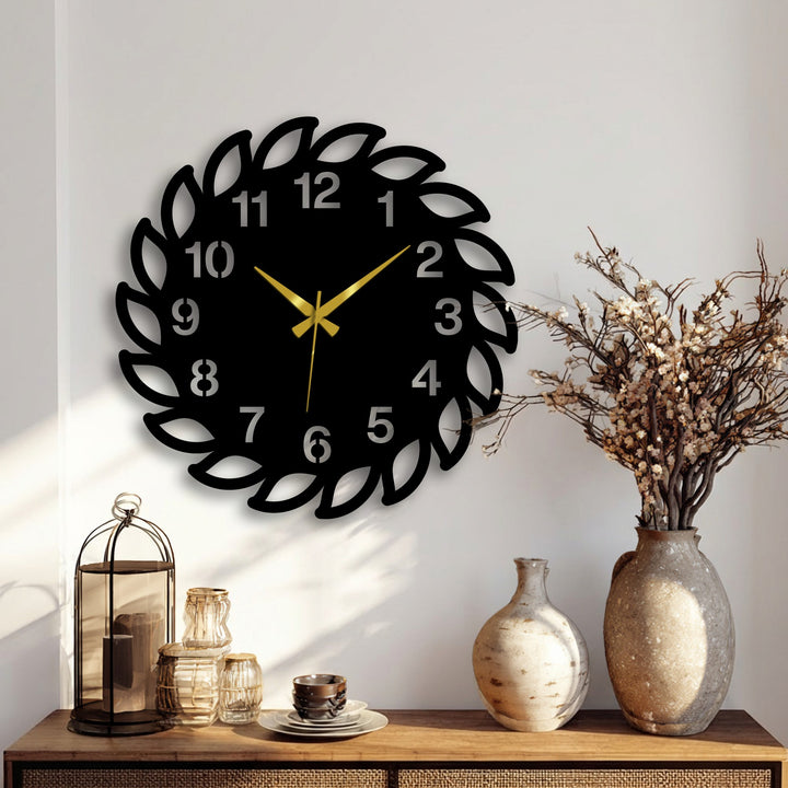 A decorative leaf frame metal wall clock showcasing intricate metal art for wall detail forms the central focal point on a bright wall above a wooden table.