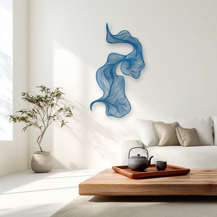 The sleek, matte surface texture of the abstract blue metal art for wall features intricately etched flowing lines against the smooth white wall.