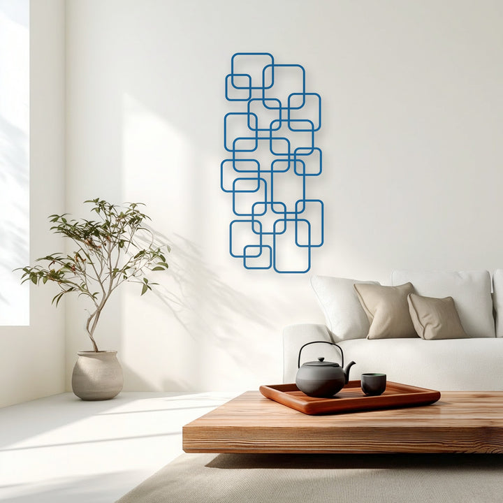 The white negative space defined by the blue geometric interlocking squares creates a striking unique metal wall art piece.