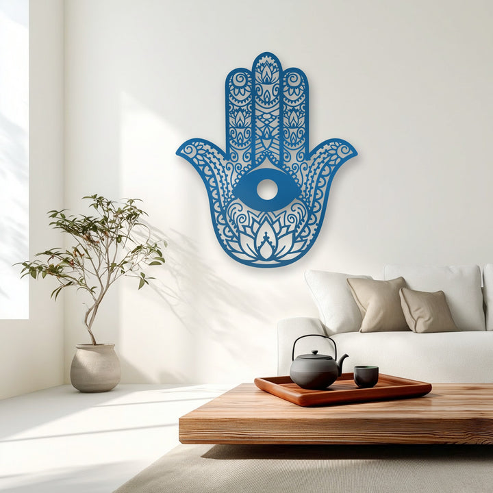 A wooden coffee table with a tea set and light rug in the foreground complements the blue Hamsa Hand evil eye metal wall decor.