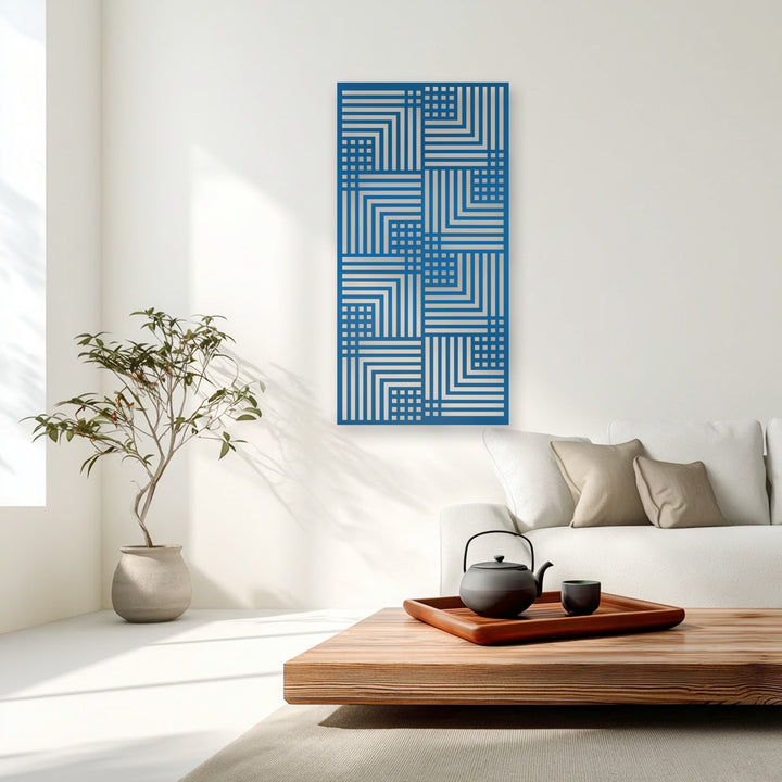 Warm color temperature defines this serene room, where sunlight enhances the cool blue and silver geometric linear pattern metal artwork.