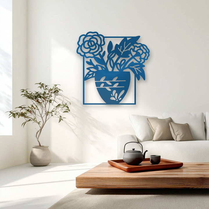 Plush neutral cushions on a white sofa complement the intricate blue floral vase silhouette decorative metal art.