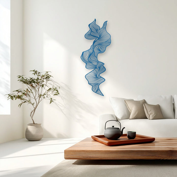 The bright blue vertical abstract flow metal wall decor provides a vibrant color contrast against the pristine white wall.