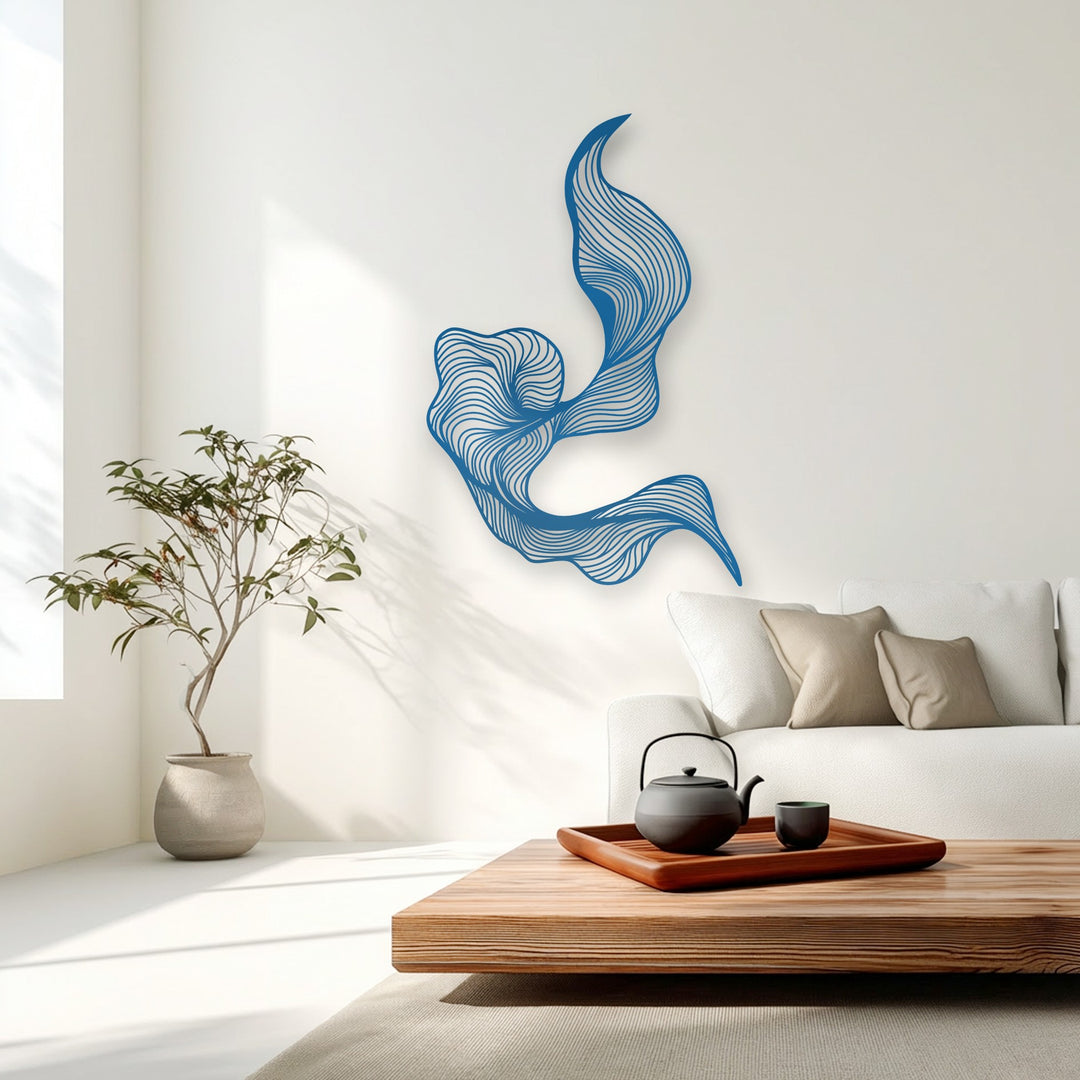 A vertically oriented, fluidly shaped abstract metal wall decor piece featuring vibrant blue flowing lines adorns a pristine white wall.