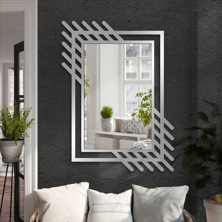 The abstract linear metal wall mirror features a unique metal wall art border with a contemporary geometric accent design along its reflective edge.