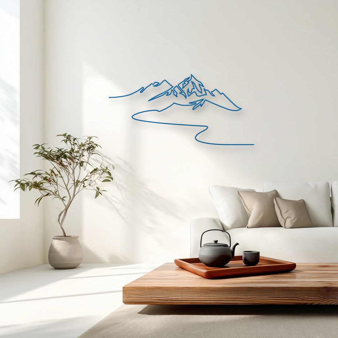 The bright, neutral color temperature of the room highlights a minimalist mountain metal artwork with a modern line design.