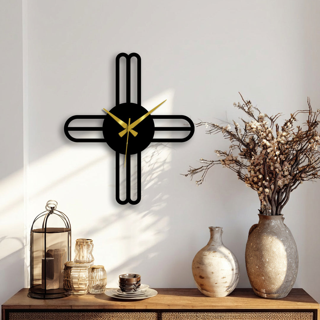 Moderate color saturation highlights the minimalist metal artwork of a modern cross line wall clock with gold hands against a neutral wall.