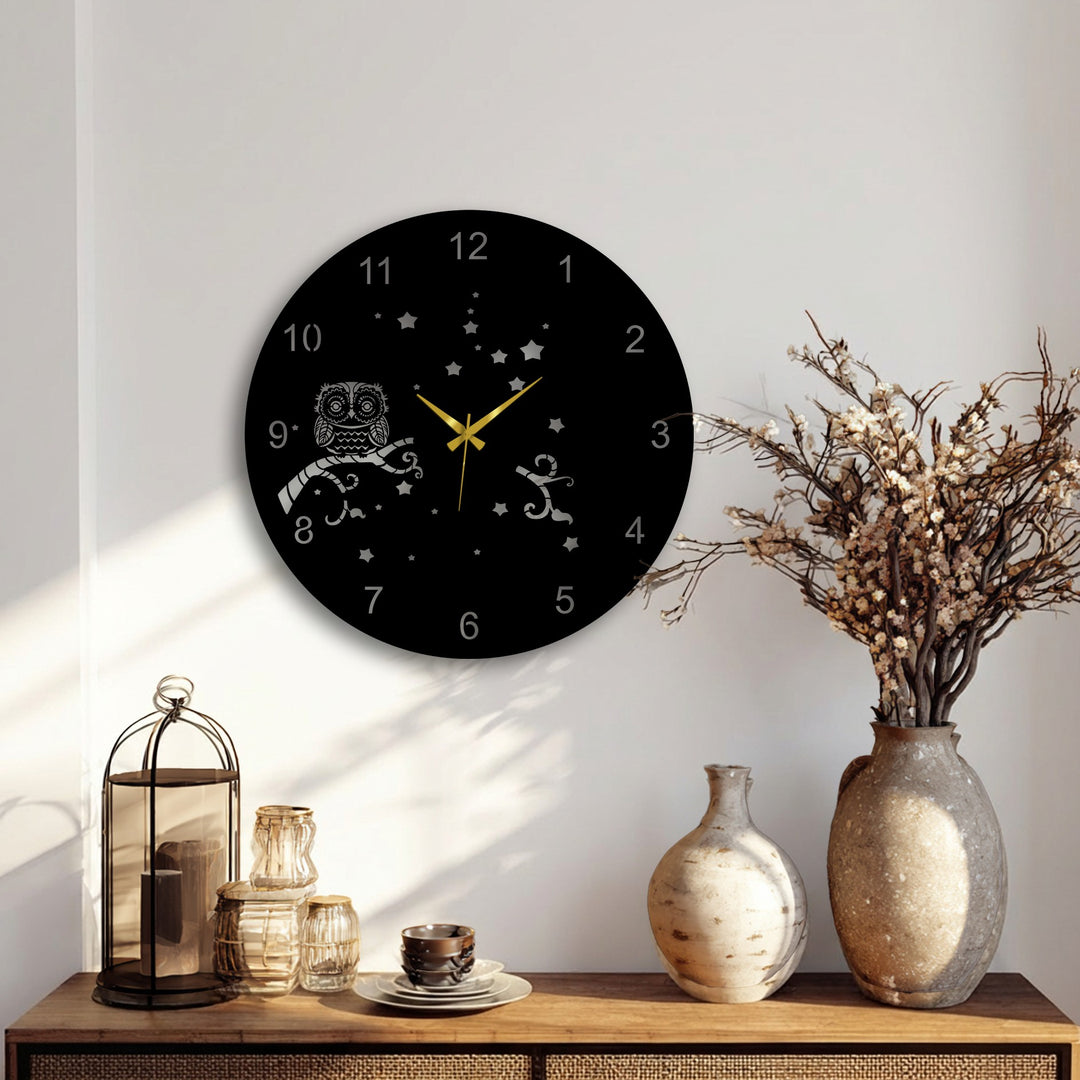 Layered golden hands and etched design on this unique metal wall art clock's black face create visual depth against the wall.