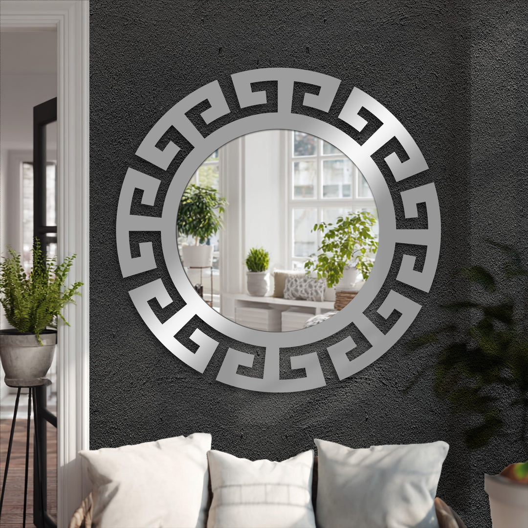 Deep shadows accentuate the textured wall behind a striking segmented Greek key round mirror for wall decor, offering a modern statement.