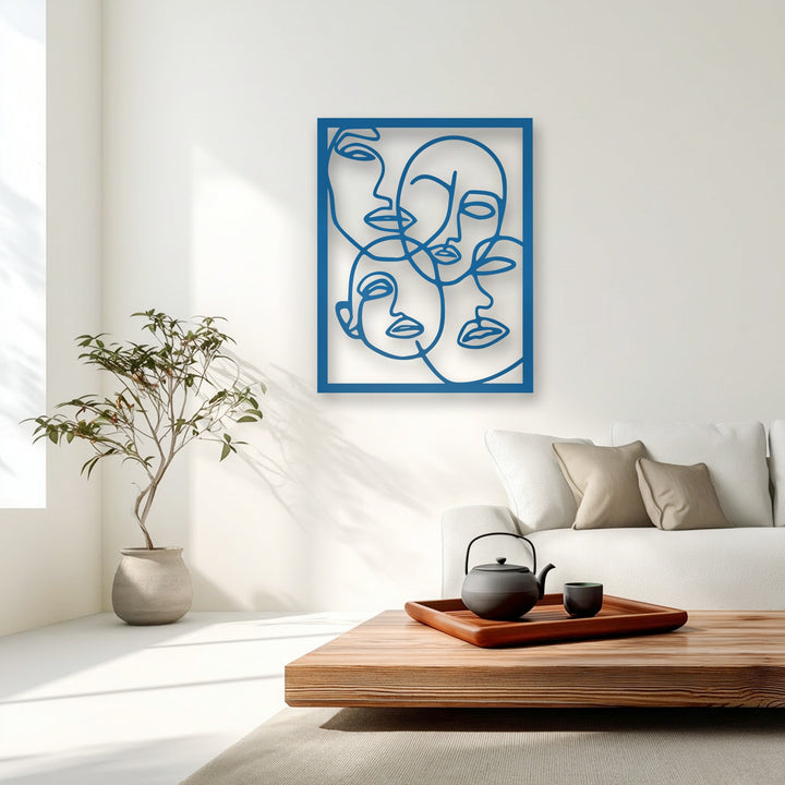 The deepest black of the teapot and cups on the table subtly highlights the bold blue abstract faces metal artwork.