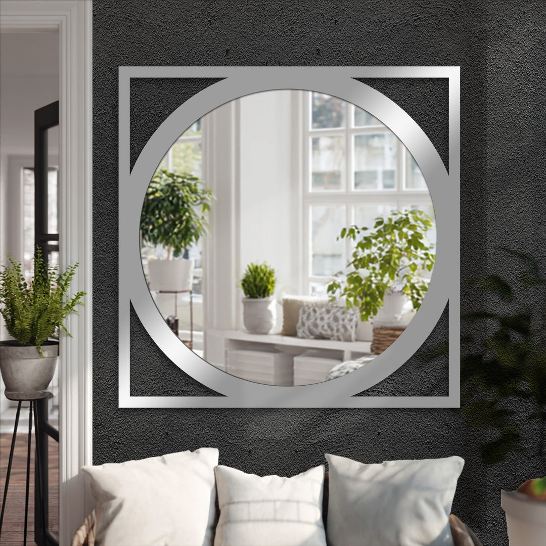 Highlighting the layering effect, this framed wall mirror features a modern round design within a square metal outline, creating geometric visual depth.