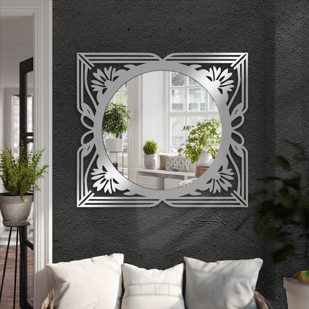 The decorative mirror showcases an elegant floral art deco frame in black metal, creating a stylish focal point in the room.