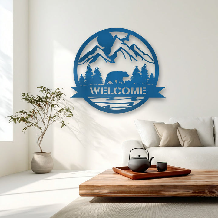 A stylish wooden coffee table with a dark cast iron teapot and cup complements the mountain bear welcome sign metal wall decor.