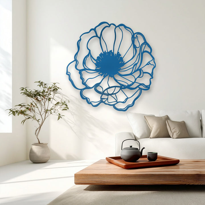The serene mood of a bright living space is enhanced by a large, deep blue minimalist floral unique metal wall art piece.