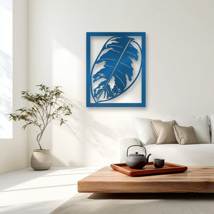 The highly saturated, vibrant blue monstera leaf metal art for wall adds a striking focal point to the serene, minimalist living space.