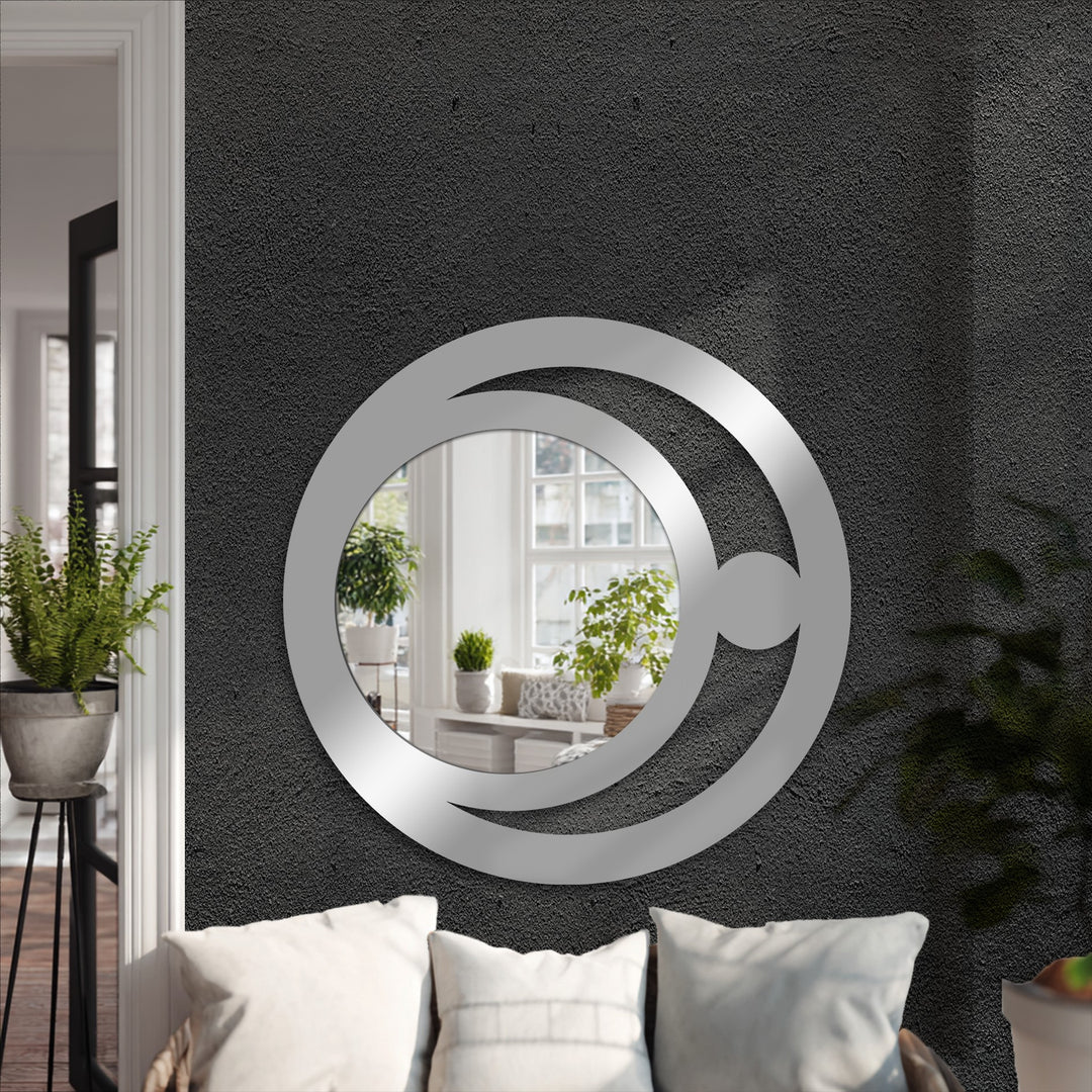 Illuminating light and shadow accentuate the round, crescent orb design of this modern metal wall decor, reflecting minimalist celestial patterns in a stylish decorative mirror.
