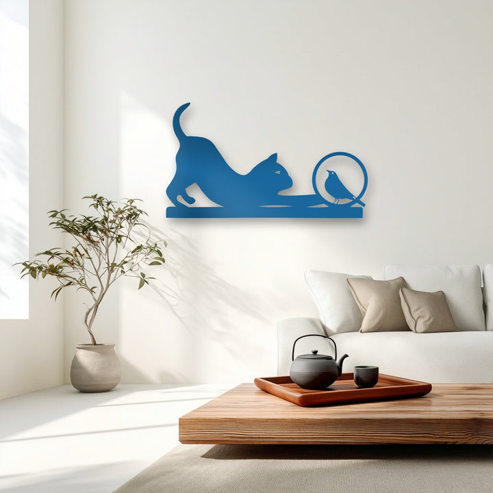 The realistic detail highlights the vibrant blue metal wall decor depicting a playful cat and curious bird silhouette, perfectly complementing the modern room.