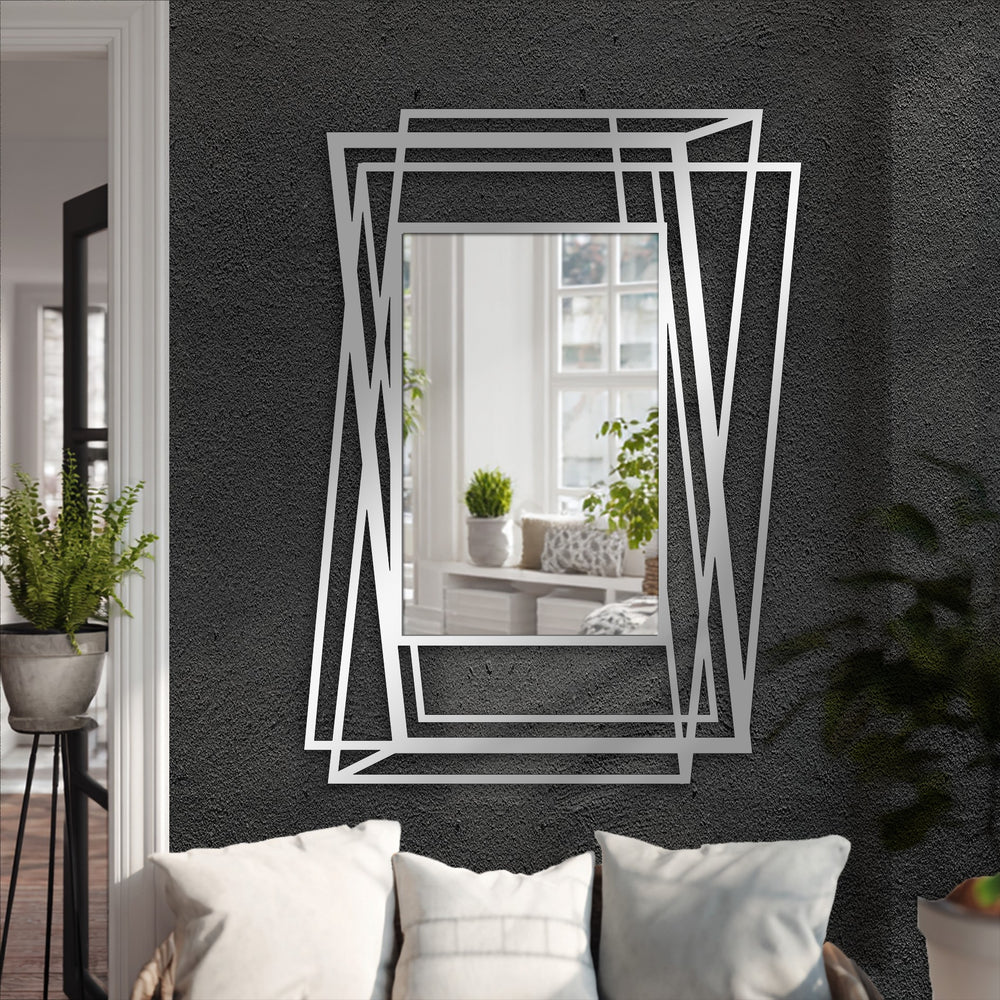 Soft, inviting throw pillows rest in the foreground below a multi-layer abstract geometric frame floor mirror, offering ideas for decorating with wall mirrors in a modern living space.