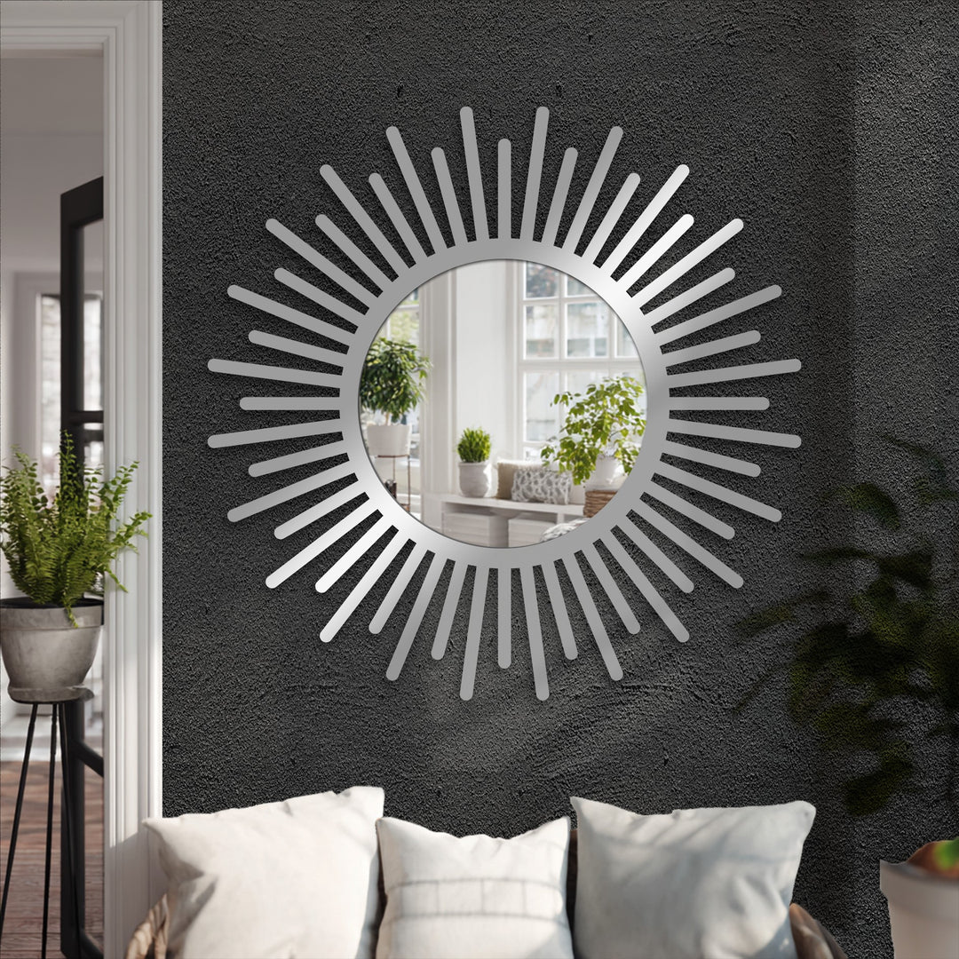 Black dominates the scene, showcasing a sunburst round floor decorative mirror reflecting a bright room with plants.