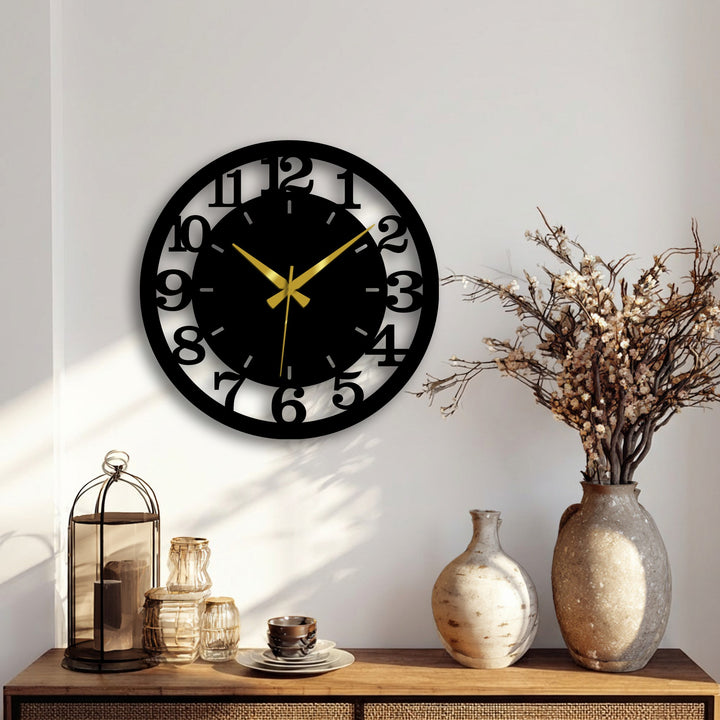 Negative space defines the modern black numbered metal artwork of the wall clock, creating striking contrast between the black numbers and negative space.
