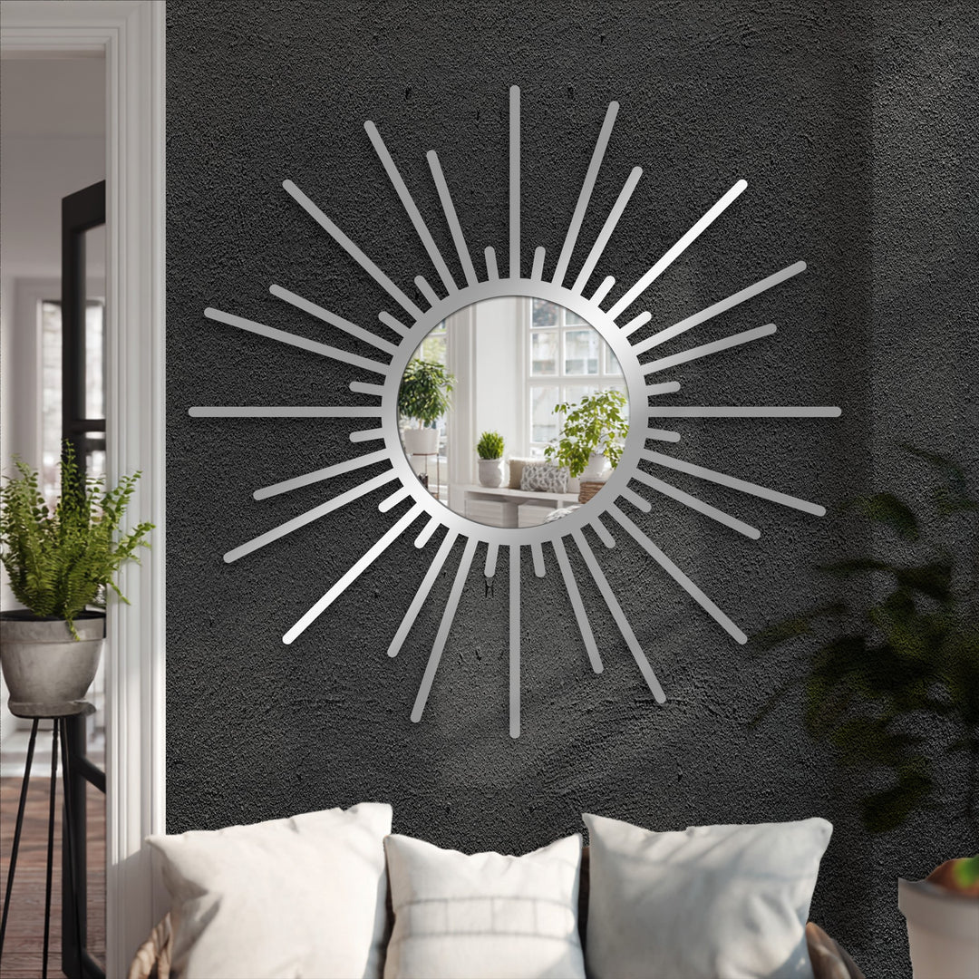 Dark gray wall showcases a modern sunburst mirror with a silver frame, a stylish piece of unique metal wall art adding a sleek, contemporary touch to the room.