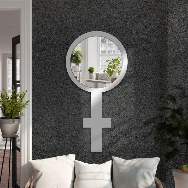 Negative space defines a symbolic floor mirror in the shape of a Venus symbol, offering a unique perspective with its black frame and decorative framed wall mirror design.