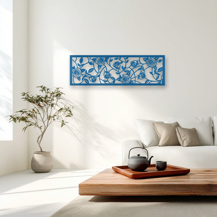 The intricate negative space of a deep blue rose floral vine metal decoration wall art reveals the pristine white wall behind it.
