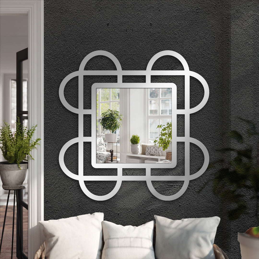 High color contrast highlights the geometric framed wall mirror's looped squares design against the dark textured wall, enhancing its decorative metal art appeal.