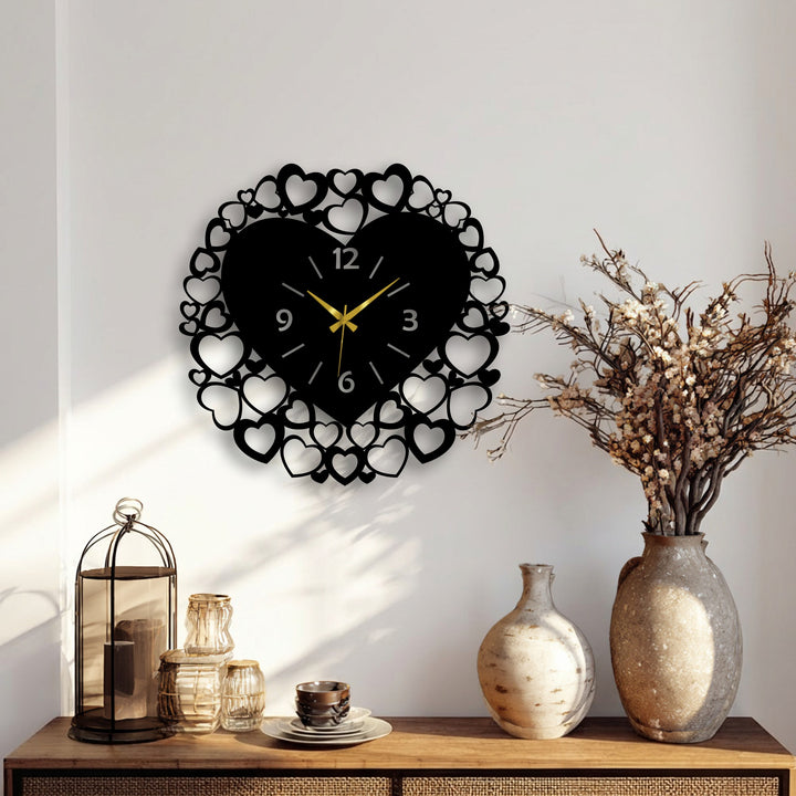 The subtle sweep of gold hands on the heart frame metal artwork clock captures time's gentle movement, bathed in dynamic sunlit patterns.