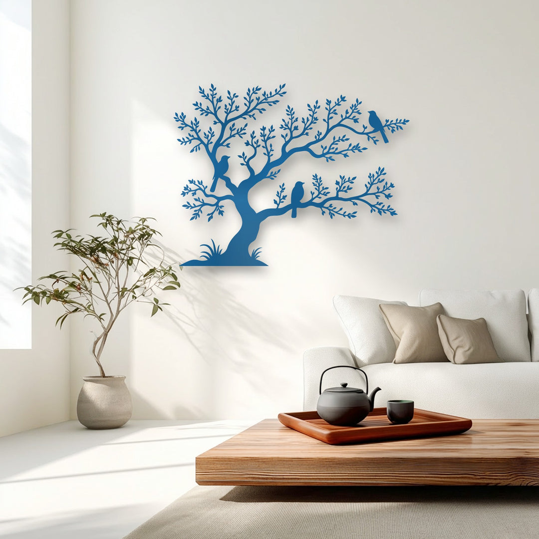 A smooth wooden coffee table holding a dark teapot and small cup sits on a beige rug, foregrounding the exquisite tree and birds metal decoration wall art.