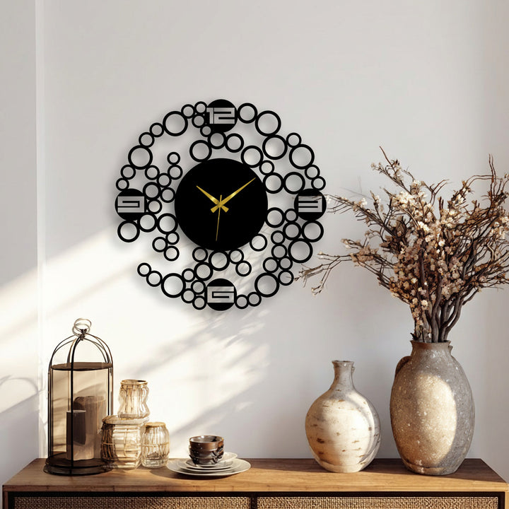 Sharp color contrast highlights the black modern bubble ring metal wall clock, a geometric design and stylish example of metal wall decor against a light backdrop.