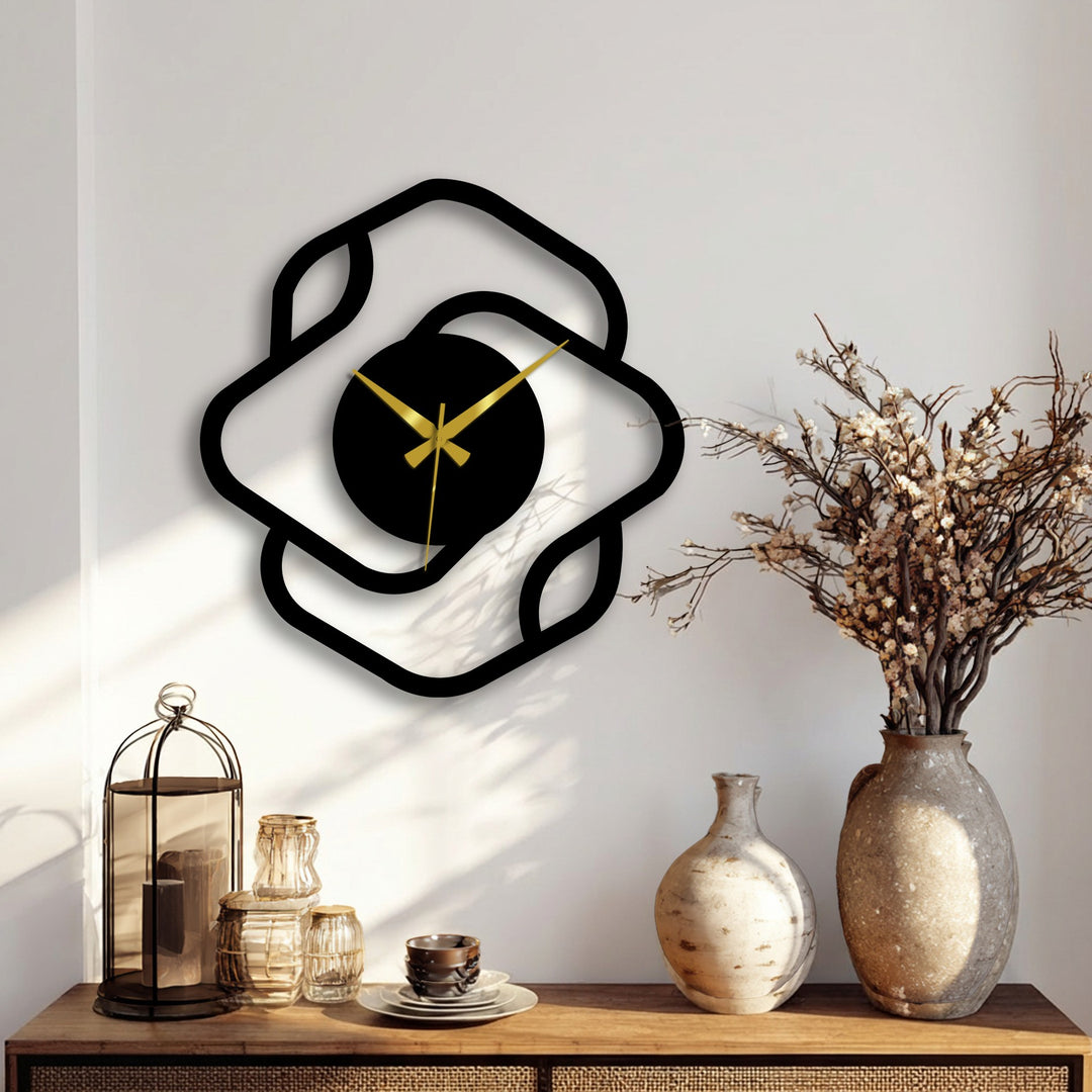 Foreground view showing a modern square frame metal wall clock with golden hands and a stylish, abstract design, displaying beautiful metal art for wall decor.