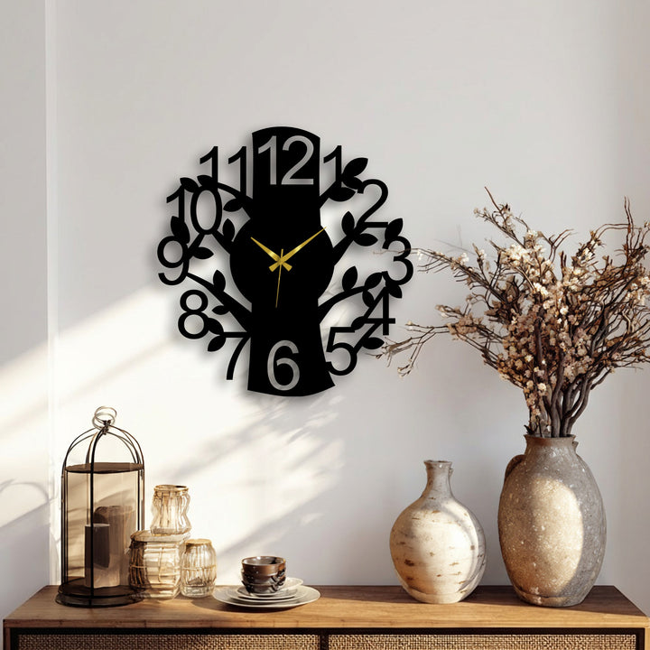 A plain white background wall highlights the nature branch metal wall clock, a decoration wall art featuring a tree design with numbers and gold hands.